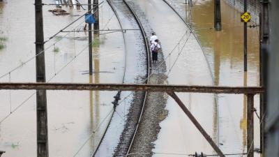 Passengers walk by train tracks submerged in water after heavy rains hit Sao Paulo, Brazil.